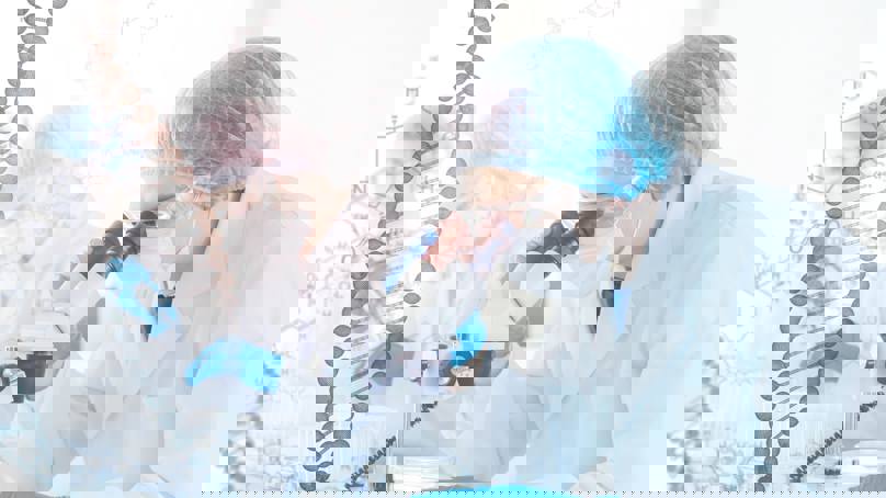 Scientist Analysing Sample Under Microscope