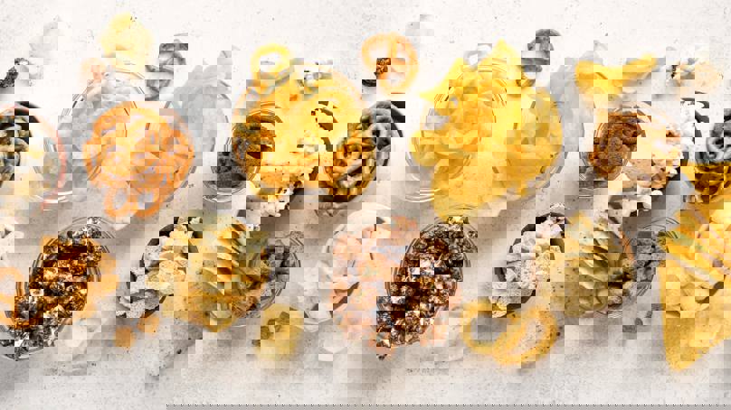 Selection Of Snack Foods Including Crisps, Popcorn And Pretzels