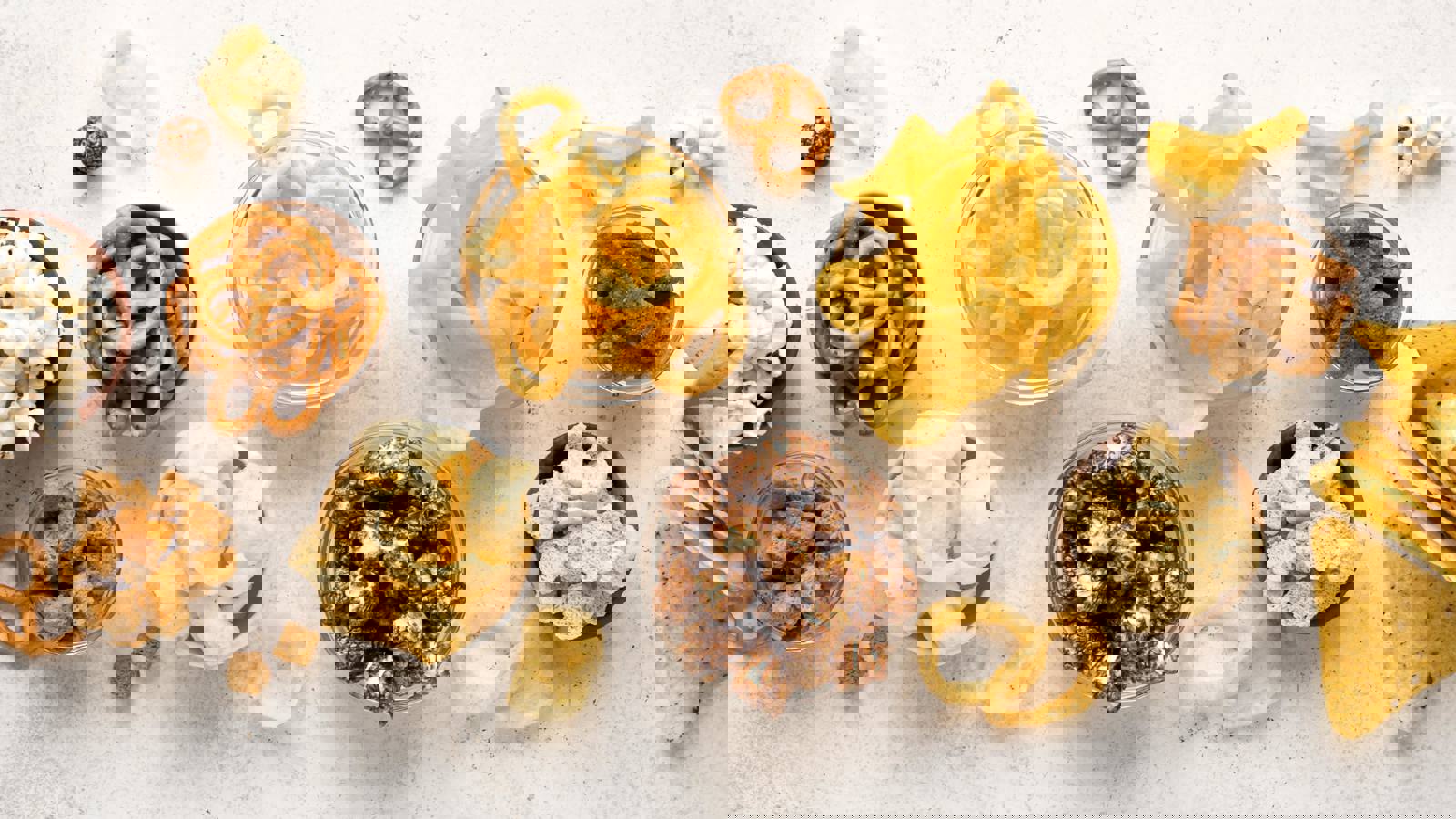 Selection of snack foods including crisps, popcorn and pretzels