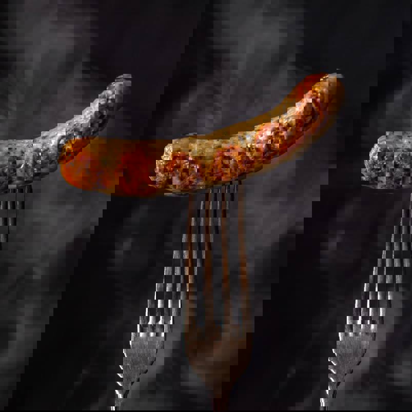 Cooked sausage pierced with fork