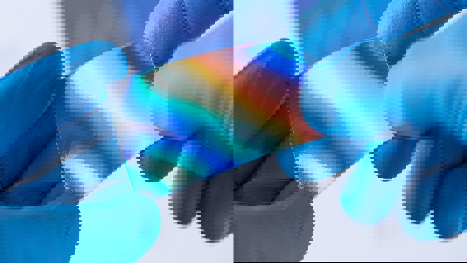 hands wearing blue gloves holding reflective material